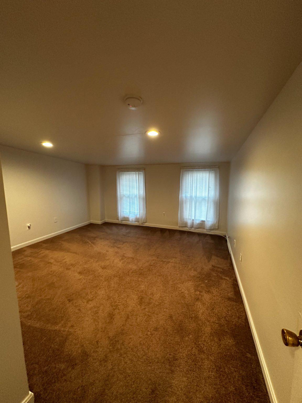 1527 West 36th Street Baltimore, MD 21211 - Photo 20 of 26 an empty room with wooden floor and windows
