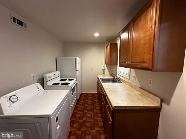 a kitchen with a sink a stove and chairs