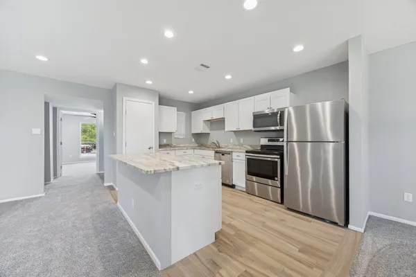 a kitchen with stainless steel appliances granite countertop a refrigerator oven a sink and dishwasher