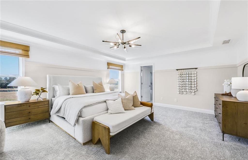 2102 Cayman Court Dacula, GA 30019 - Photo 11 of 18 a spacious bedroom with a bed and a chandelier