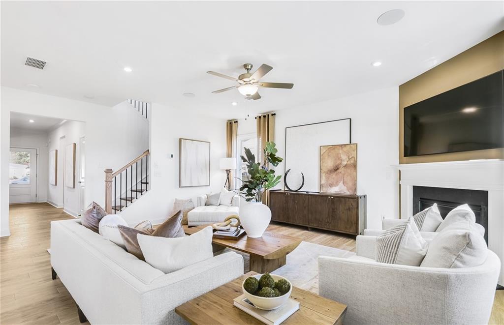 2102 Cayman Court Dacula, GA 30019 - Photo 5 of 18 a living room with furniture a flat screen tv and a fireplace