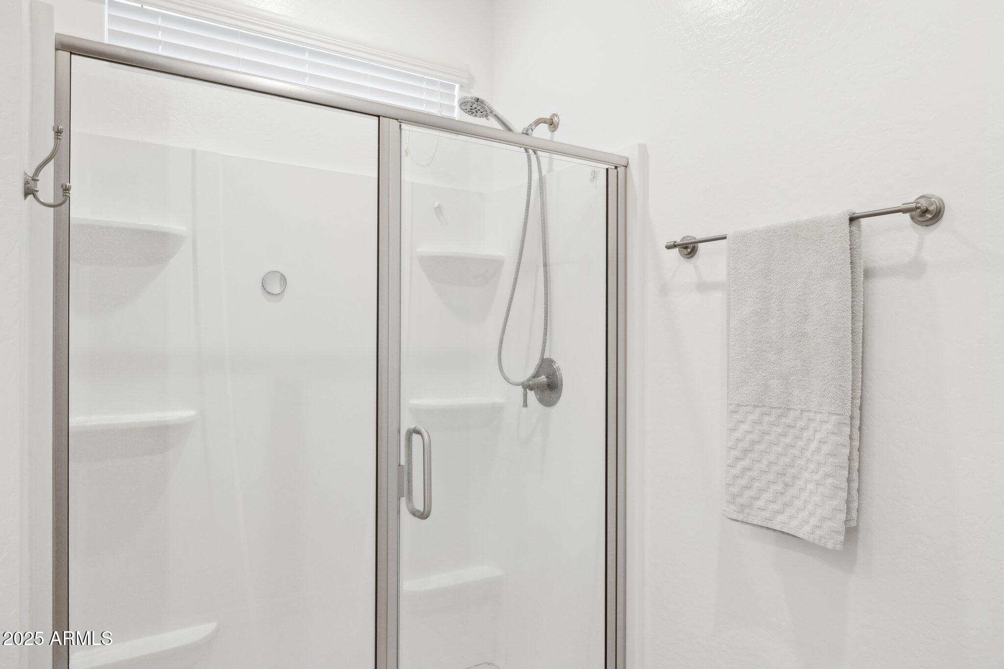 14360 West Pershing Street Surprise, AZ 85379 - Photo 14 of 24 a bathroom with a glass shower door