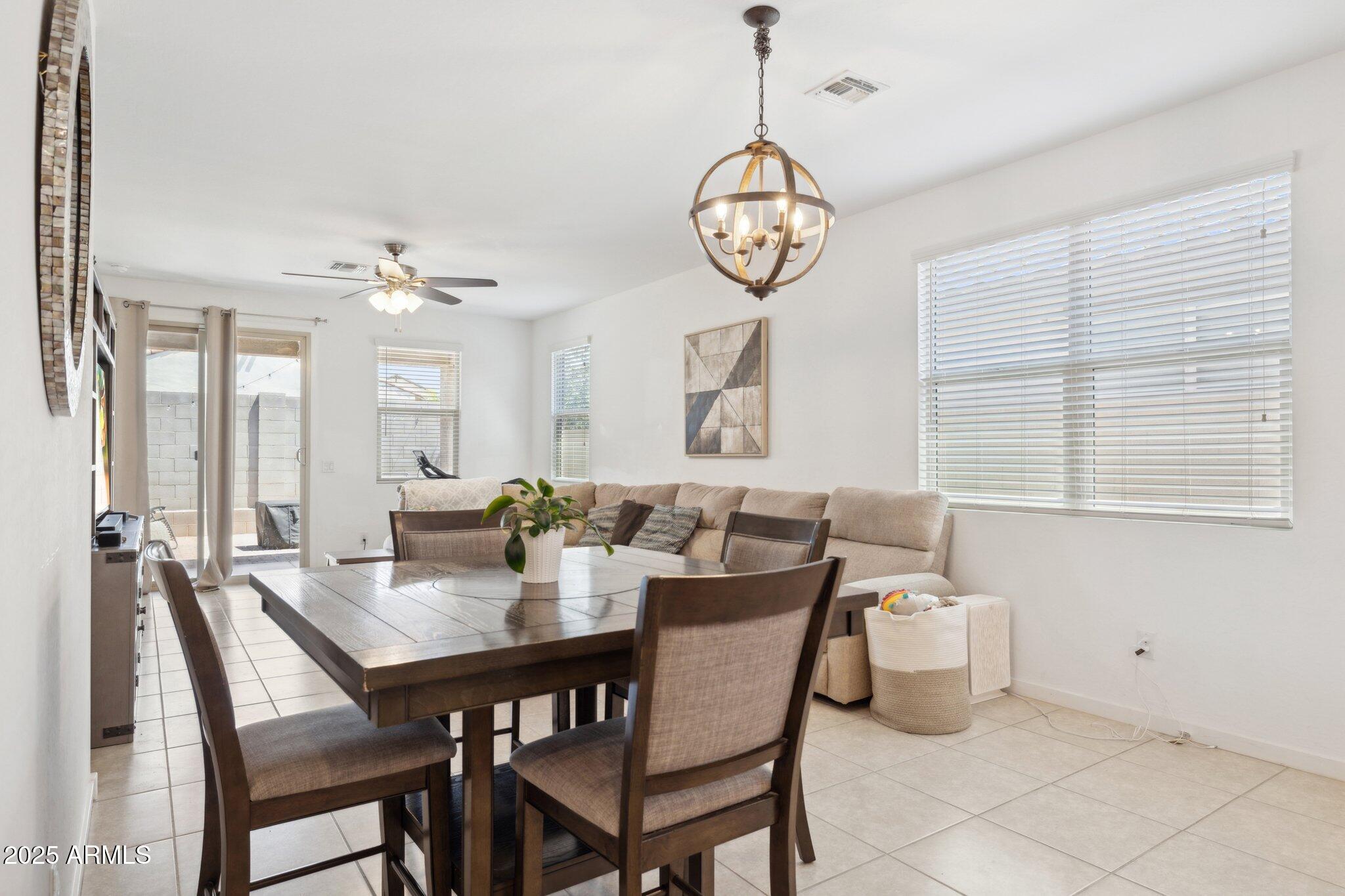 14360 West Pershing Street Surprise, AZ 85379 - Photo 6 of 24 a view of a dining room and livingroom with furniture wooden floor and a chandelier