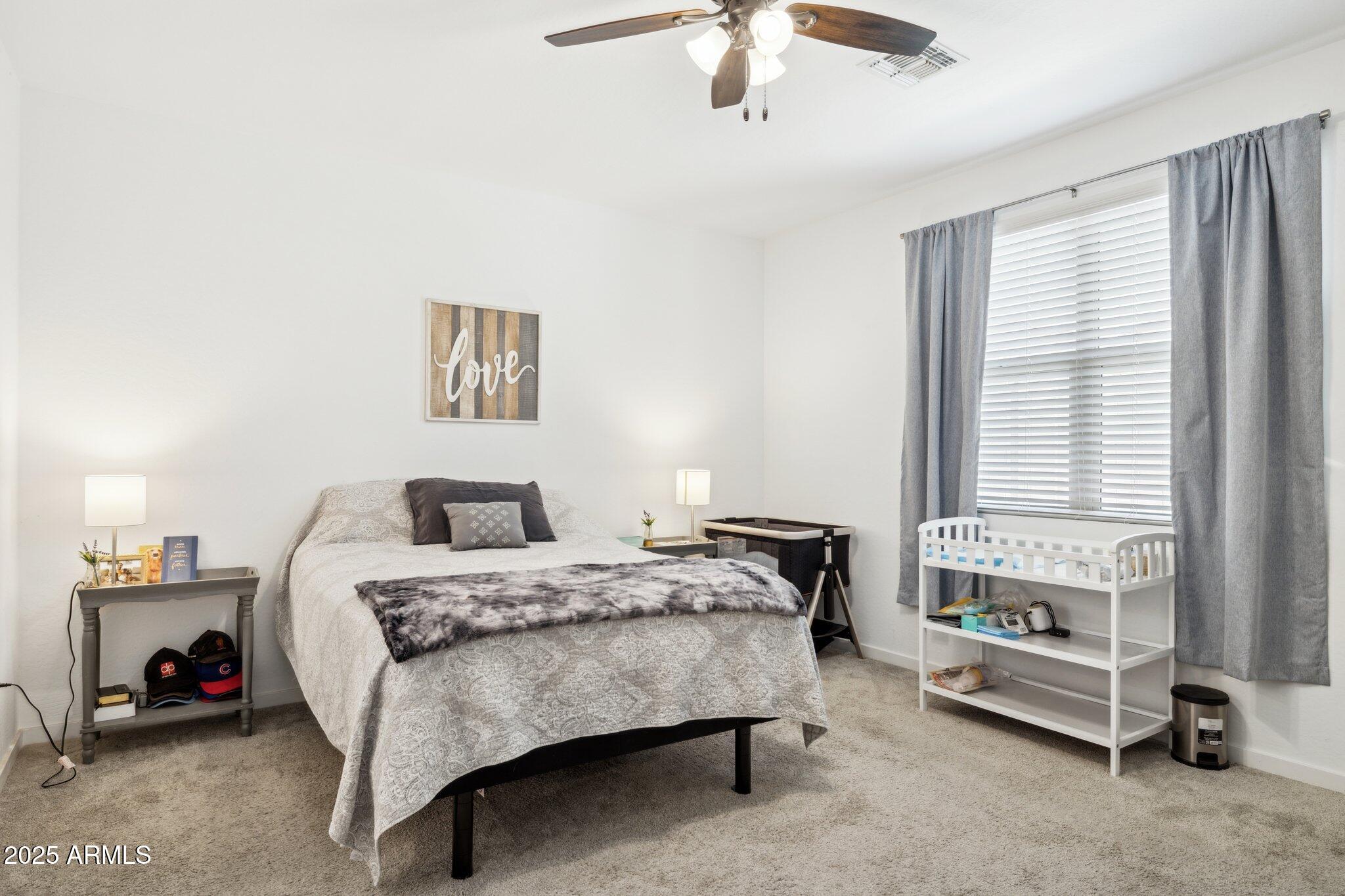 14360 West Pershing Street Surprise, AZ 85379 - Photo 10 of 24 a bedroom with a bed and a chandelier