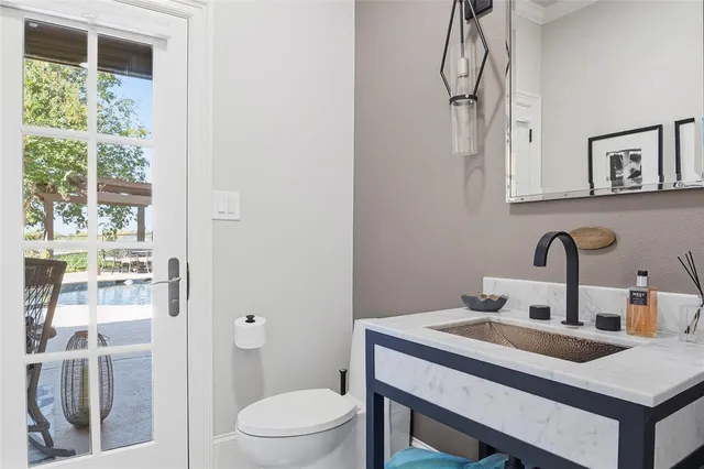 a bathroom with a sink vanity mirror and toilet