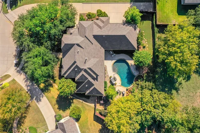 an aerial view of a house with swimming pool and garden