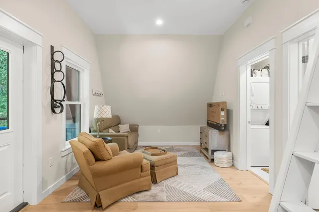a living room with furniture a rug and a window