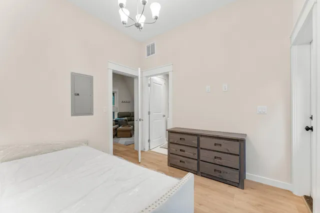 a spacious bedroom with a bed and a chandelier