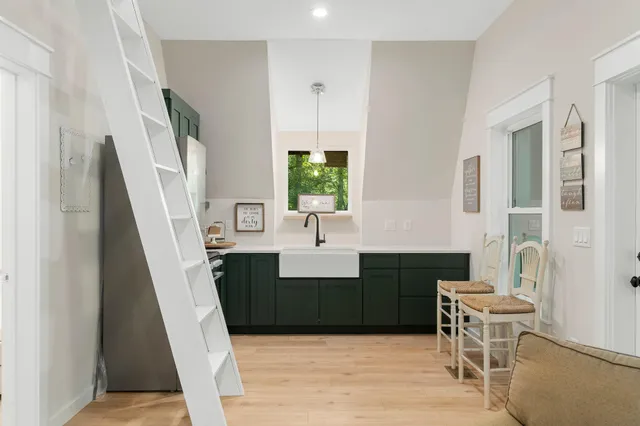 a view of kitchen with sink microwave and wooden floor