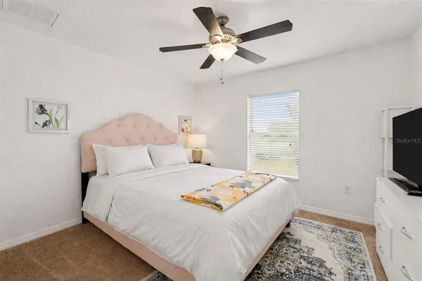 a bed room with a bed a television and a dresser