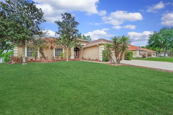 a view of a house with a big yard and potted plants