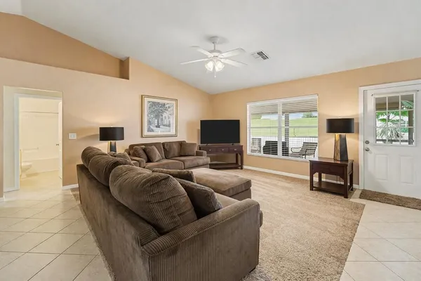 a living room with furniture and a flat screen tv with wooden floor