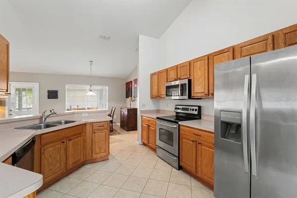 a large kitchen with stainless steel appliances granite countertop a sink stove oven and refrigerator