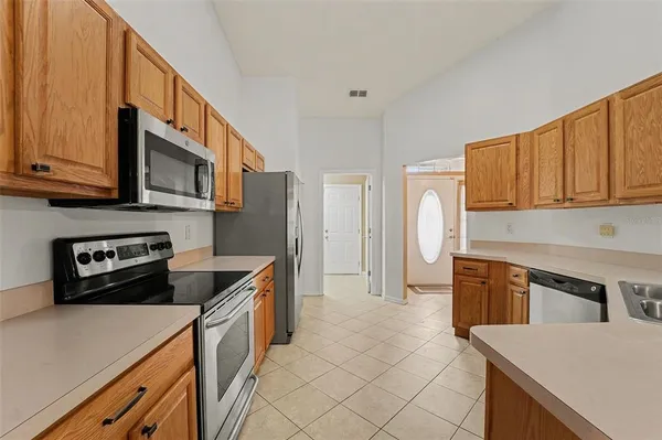 a kitchen with stainless steel appliances granite countertop a refrigerator a stove top oven a sink and dishwasher