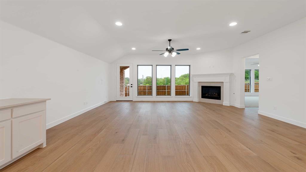 829 Stoney Bridge Way Lavon, TX 75166 - Photo 12 of 35 a view of an empty room with wooden floor and a window