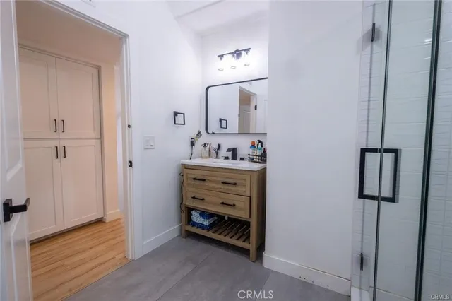 a bathroom with a double vanity sink and glass door