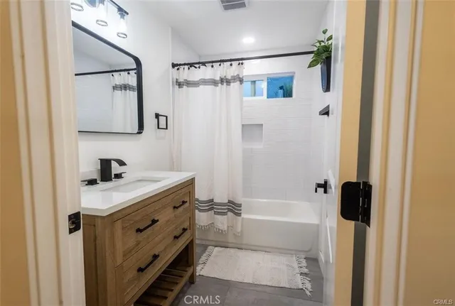 a view of a hallway with wooden floor and a bathroom