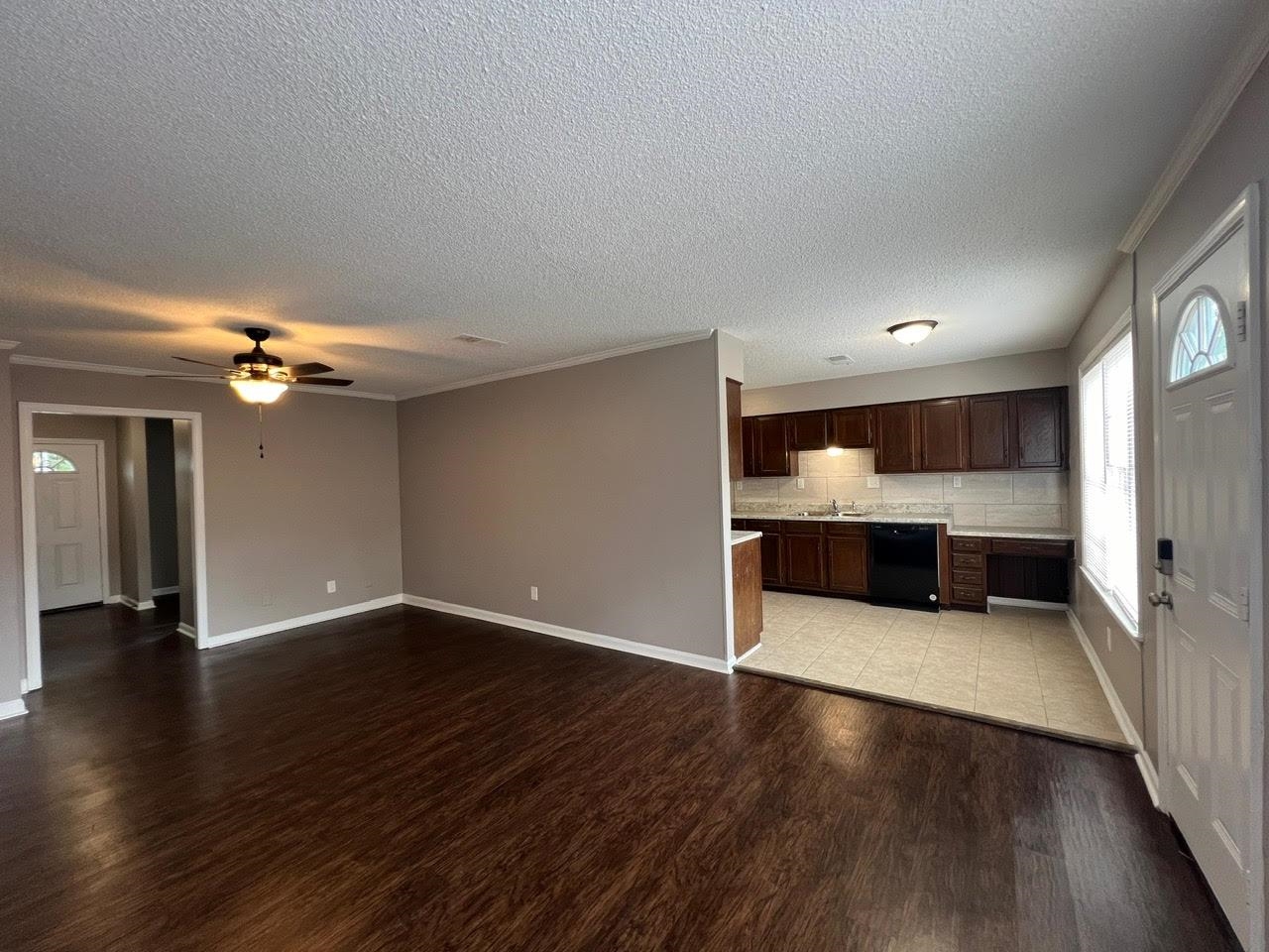 5995 Lofty Oak Road, Unit 5995 Memphis, TN 38115 - Photo 12 of 20 Unfurnished living room featuring sink, light wood-type flooring, a textured ceiling, ceiling fan, and ornamental molding