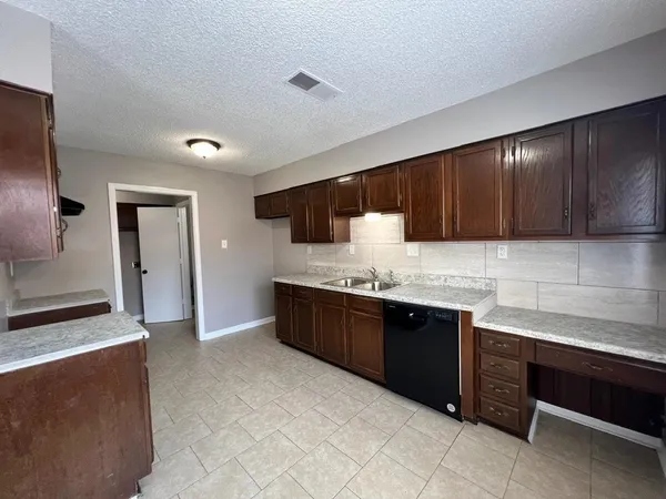 a large kitchen with stainless steel appliances granite countertop a sink and a stove