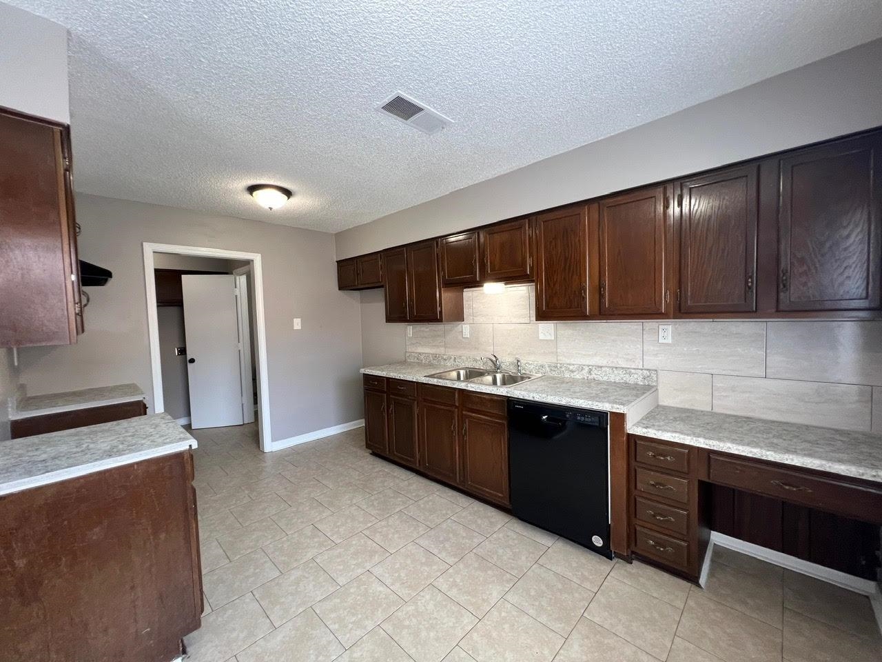 5995 Lofty Oak Road, Unit 5995 Memphis, TN 38115 - Photo 2 of 20 Kitchen featuring light tile patterned flooring, dishwasher, decorative backsplash, dark brown cabinetry, and sink