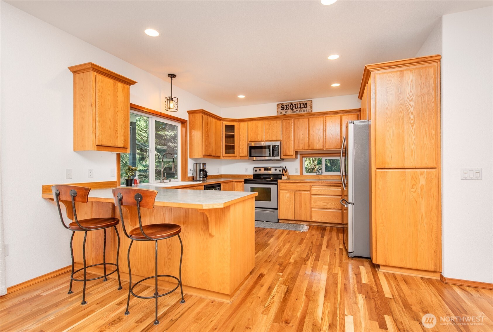 31 Josephine Place Sequim, WA 98382 - Photo 13 of 40 a kitchen with stainless steel appliances granite countertop a refrigerator a stove top oven and a sink with wooden floor