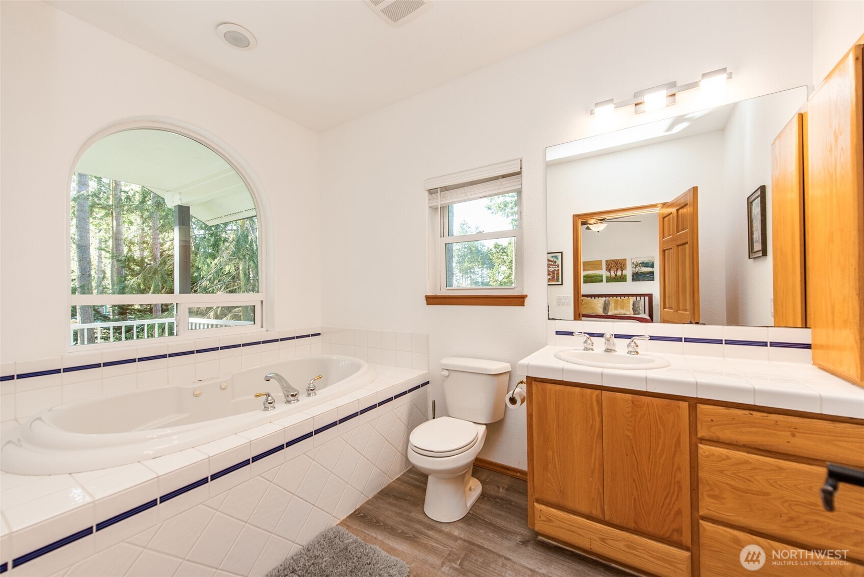 31 Josephine Place Sequim, WA 98382 - Photo 23 of 40 a bathroom with a granite countertop toilet a sink and a large mirror