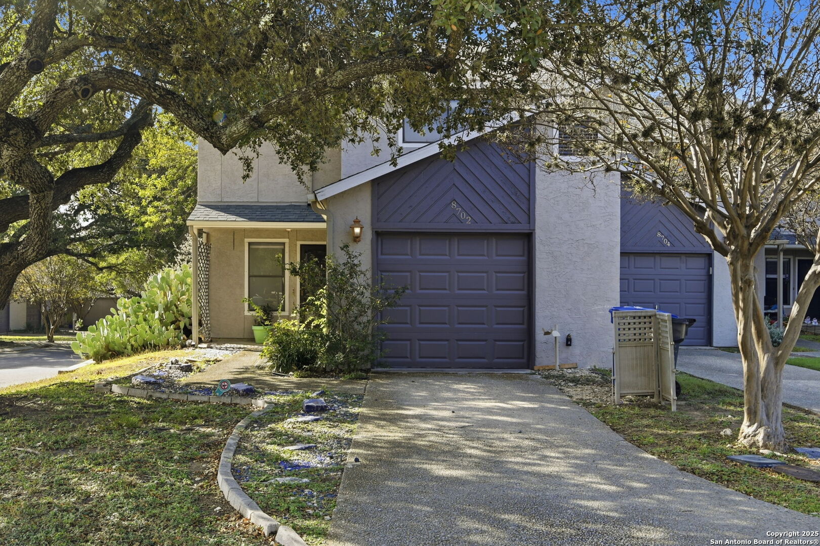 a view of a brick house with a large tree