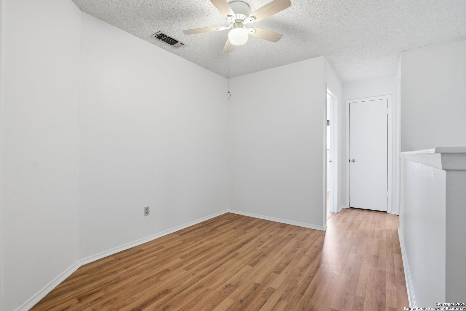 8702 Stream Circle San Antonio, TX 78250 - Photo 11 of 18 a view of a room with wooden floor and white walls