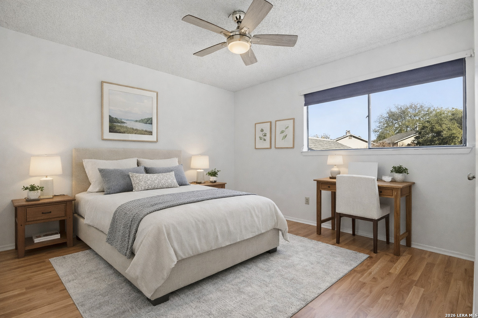8702 Stream Circle San Antonio, TX 78250 - Photo 12 of 18 a bedroom with a bed a table and a painting on the wall