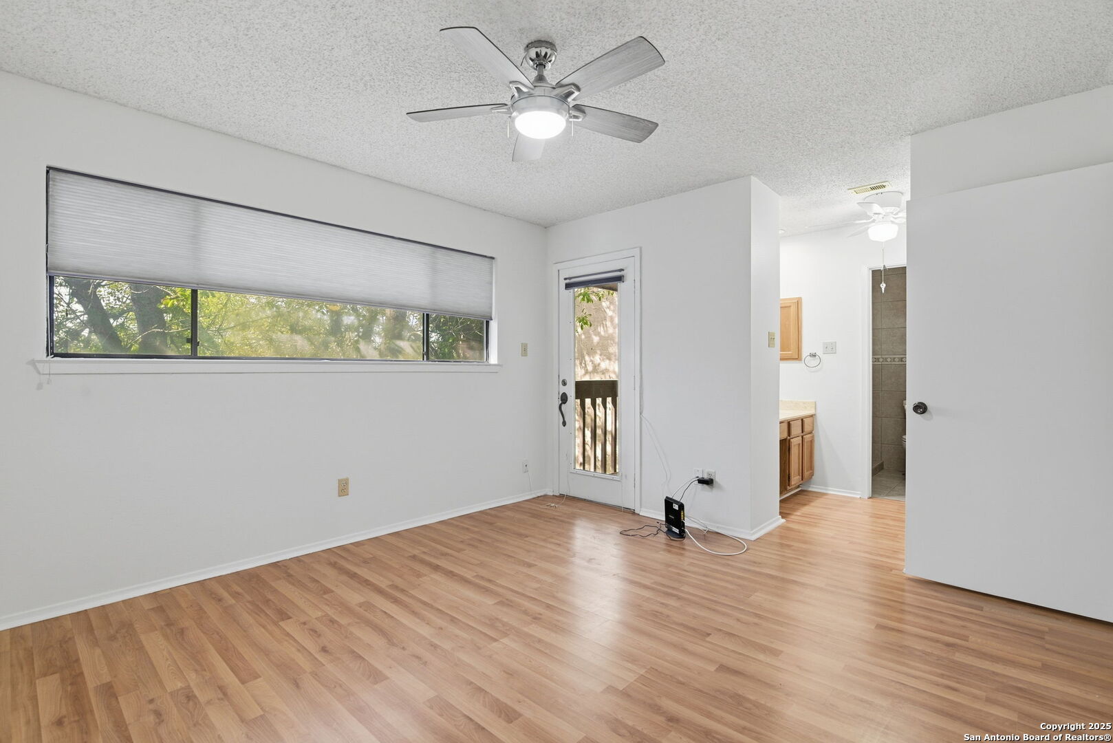 8702 Stream Circle San Antonio, TX 78250 - Photo 13 of 18 an empty room with wooden floor and windows