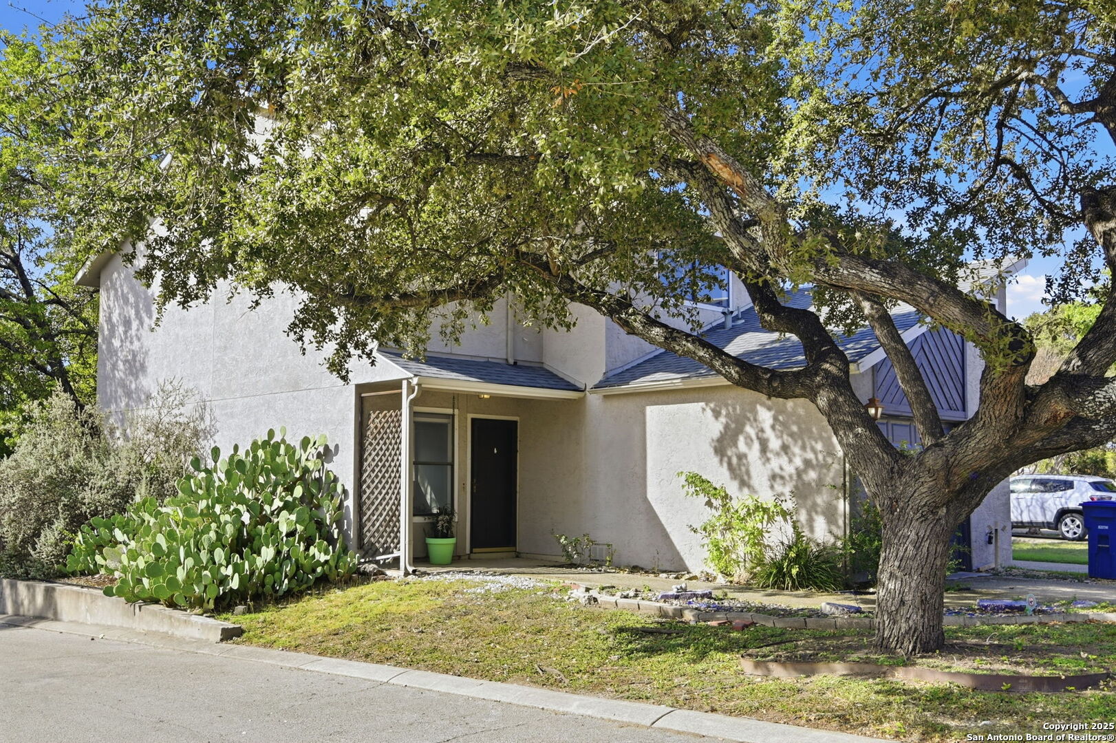 8702 Stream Circle San Antonio, TX 78250 - Photo 17 of 18 a front view of a house with garden and trees