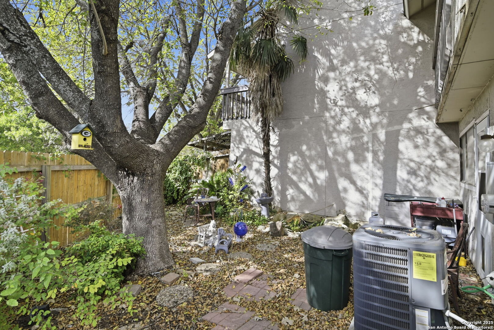 8702 Stream Circle San Antonio, TX 78250 - Photo 18 of 18 a view of a backyard with fountain plants and large trees