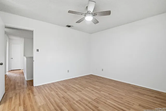 a view of empty room with wooden floor