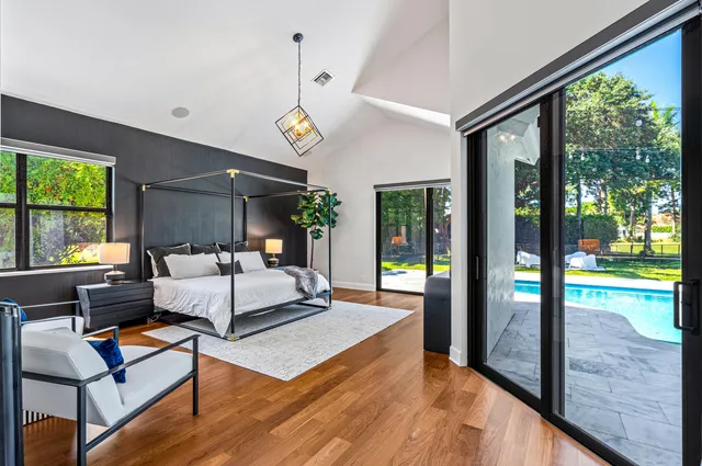 a bedroom with a bed and a large window with balcony view