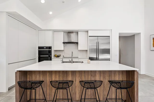 a kitchen with a sink and chairs