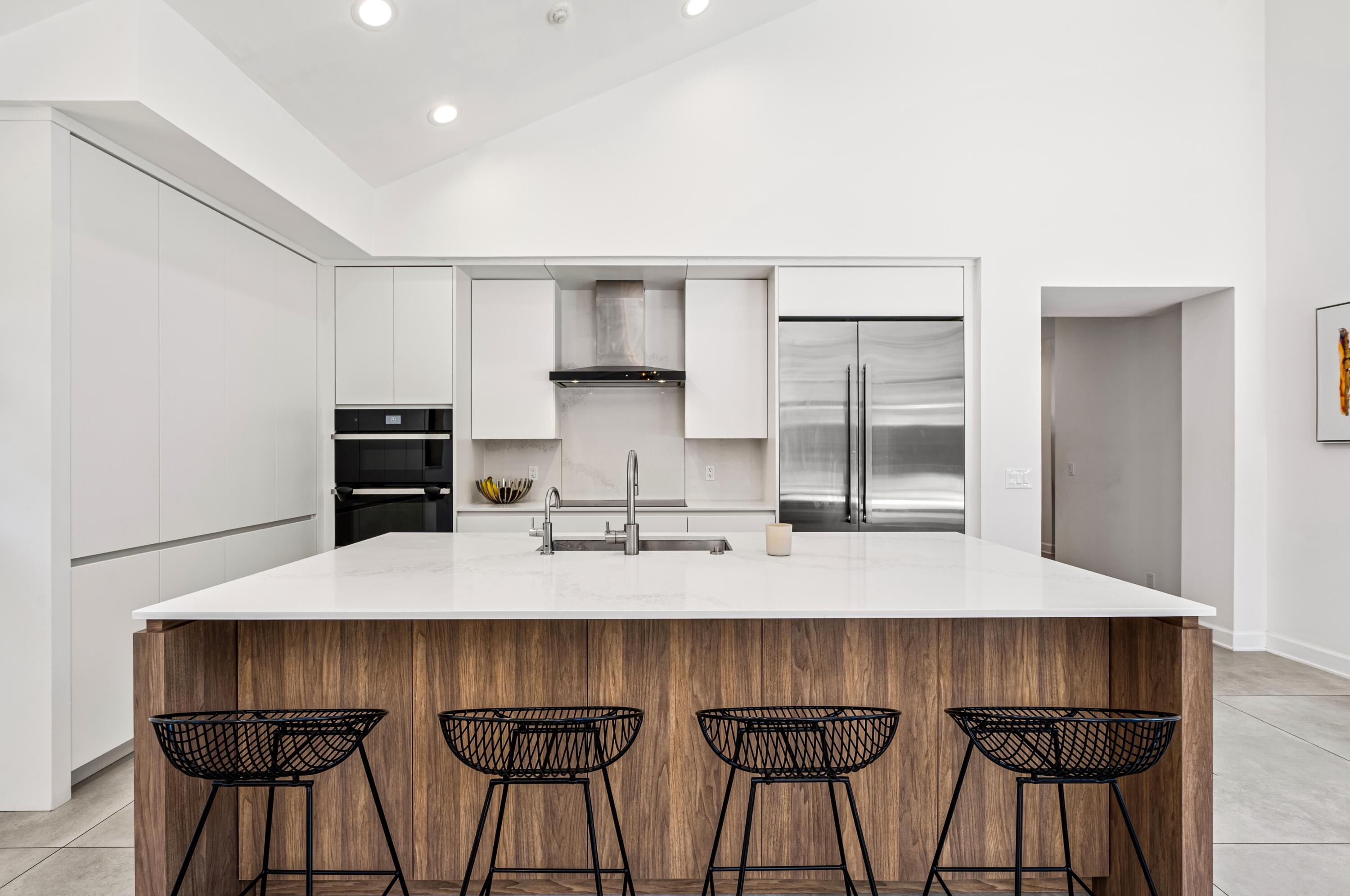 3098 Northwest 60th Street Boca Raton, FL 33496 - Photo 8 of 30 a kitchen with stainless steel appliances a kitchen island a table and chairs in it
