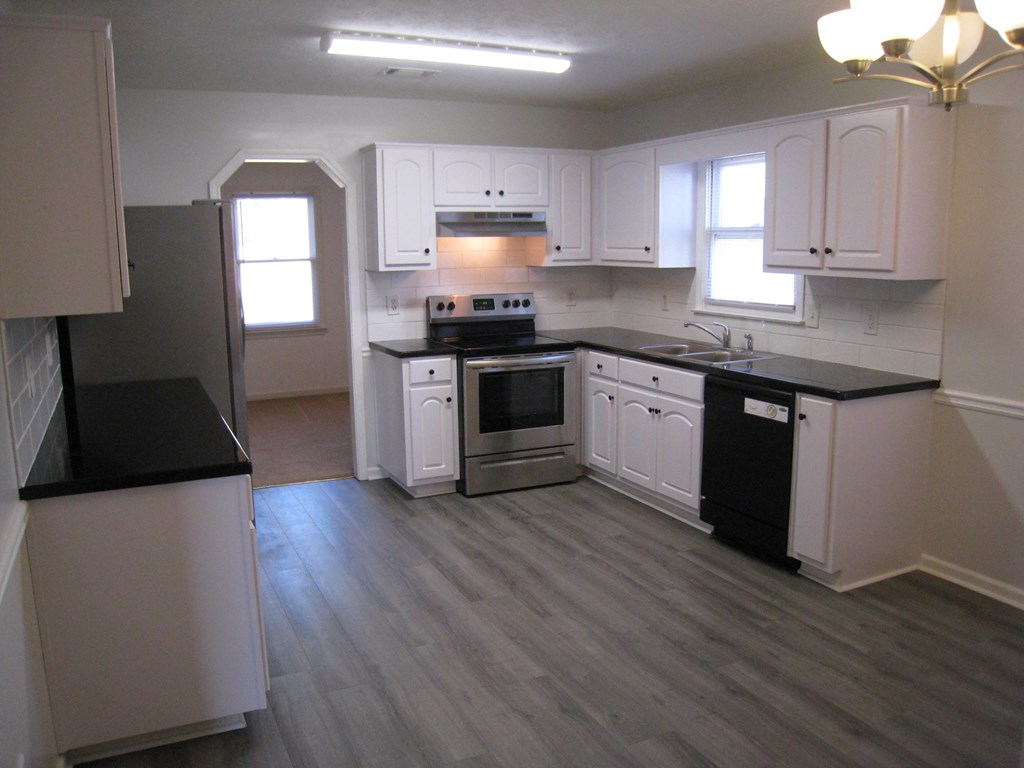 3371 Flintlock Drive Columbus, GA 31907 - Photo 5 of 14 a kitchen with granite countertop a stove top oven sink and cabinets