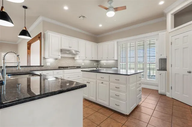 a kitchen with stainless steel appliances granite countertop a sink a stove and a wooden floors