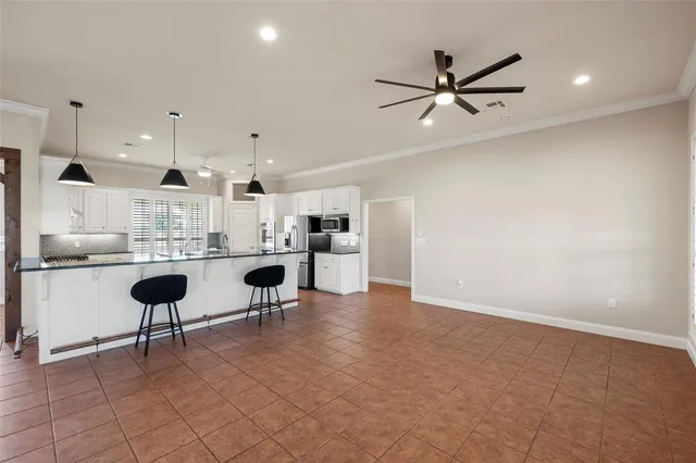 a kitchen with a dining table chairs sink and white appliances