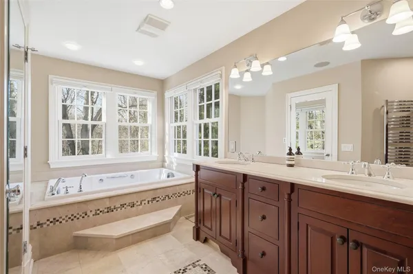 a spacious bathroom with double vanity a window a double vanity sinks and a bathtub