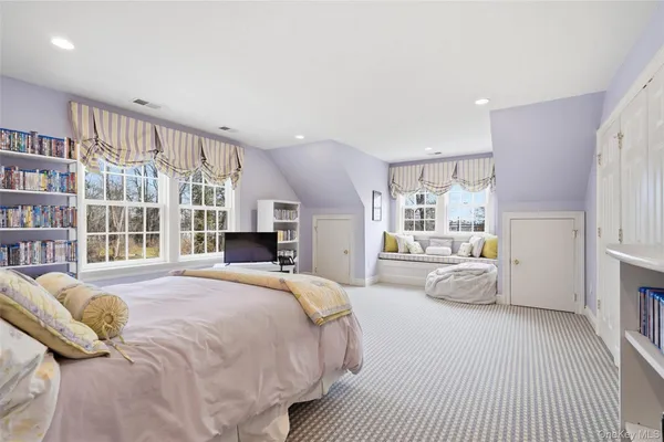 a spacious bedroom with a large bed and a large window