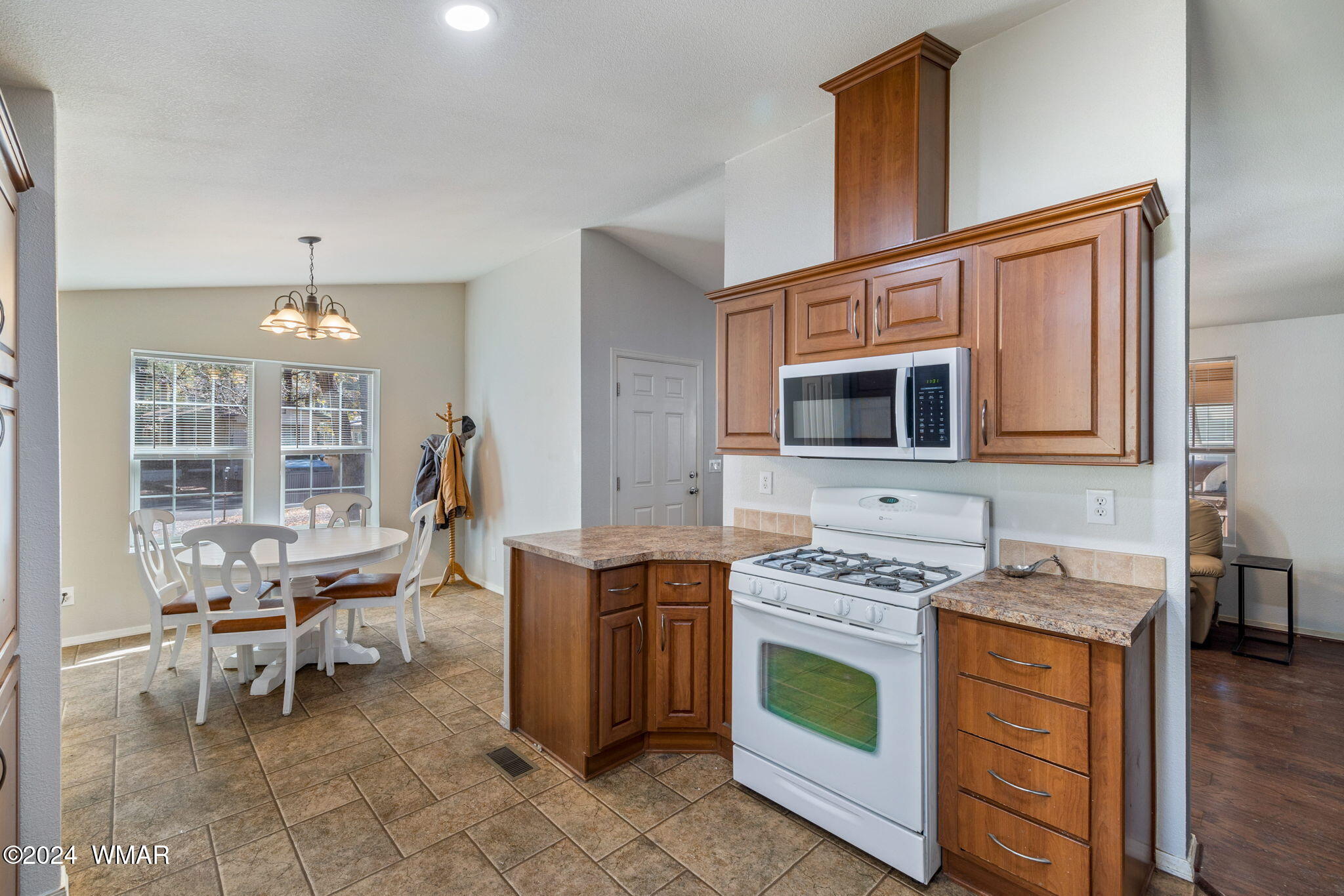 4286 East Blue Ridge Loop Pinetop, AZ 85935 - Photo 11 of 29 a kitchen with stainless steel appliances a stove top oven a sink a dining table and chairs