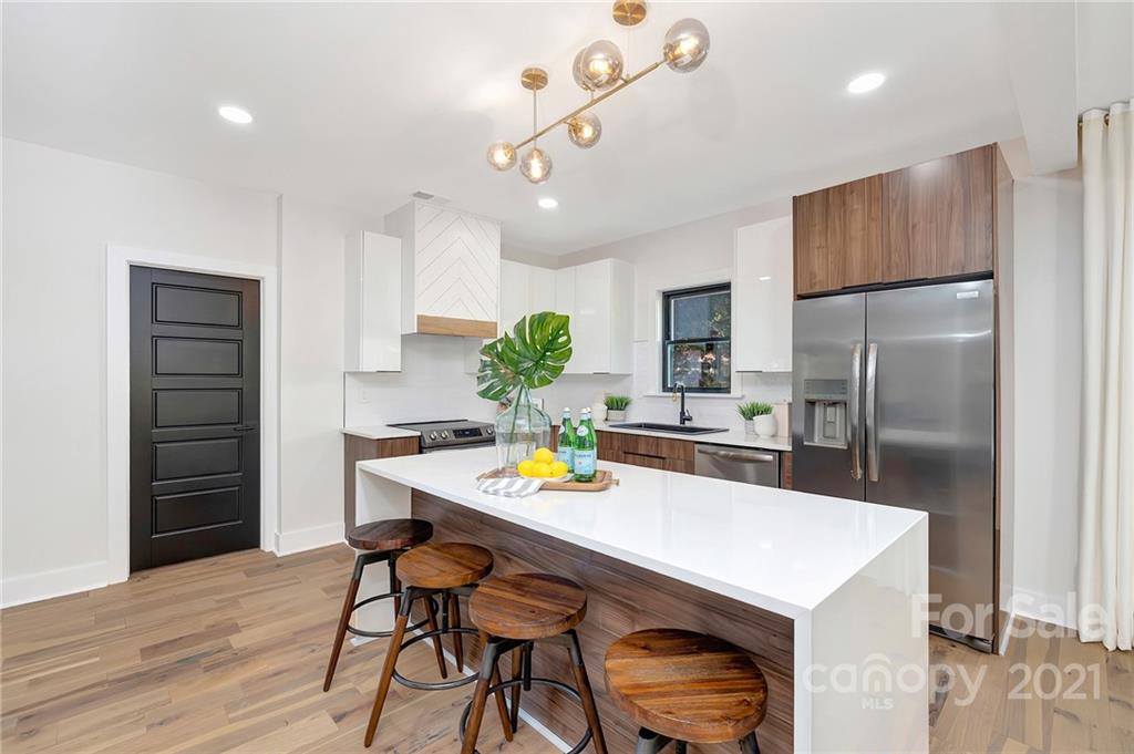 4122 Applegate Road Charlotte, NC 28209 - Photo 4 of 17 a kitchen with stainless steel appliances a dining table chairs refrigerator and microwave