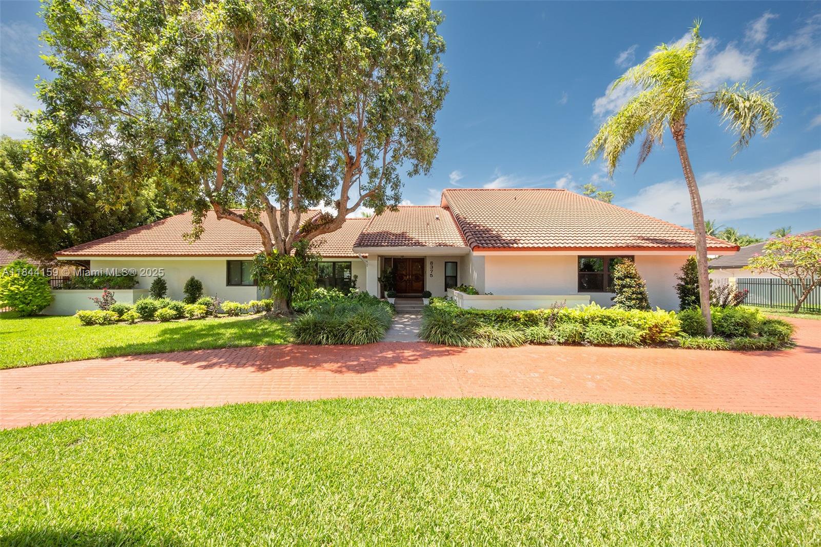 8375 Southwest 78th Street Miami, FL 33143 - Photo 6 of 45 a front view of a house with a yard and potted plants