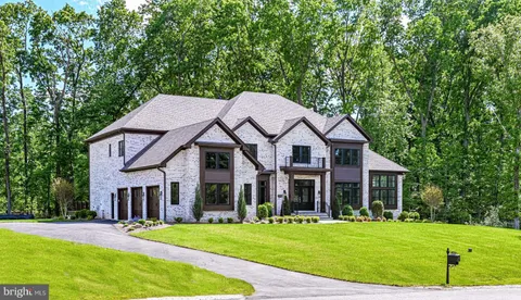 a view of a big house with a big yard and large trees