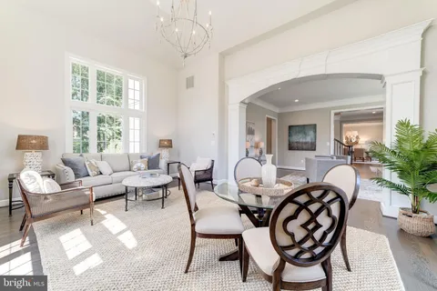 a living room with furniture a chandelier and a dining table