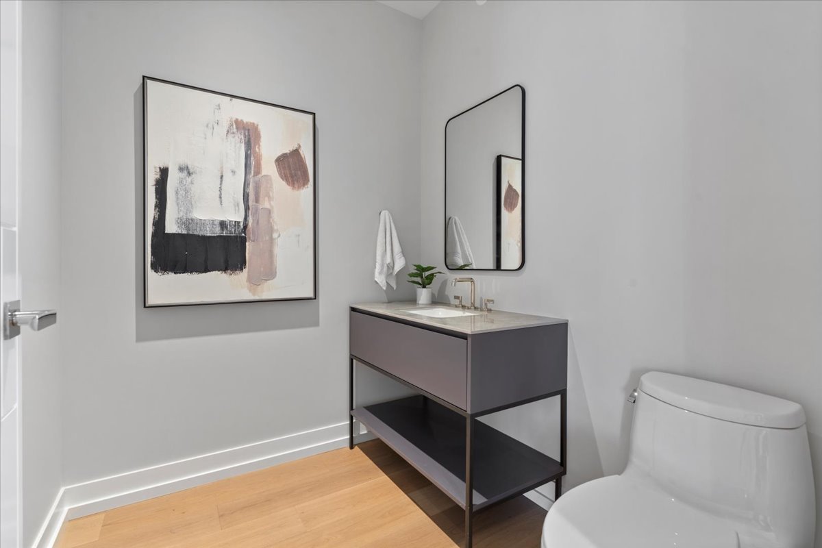 14 West Superior Street, Unit 5003 Chicago, IL 60654 - Photo 12 of 37 a bathroom with a toilet sink and mirror
