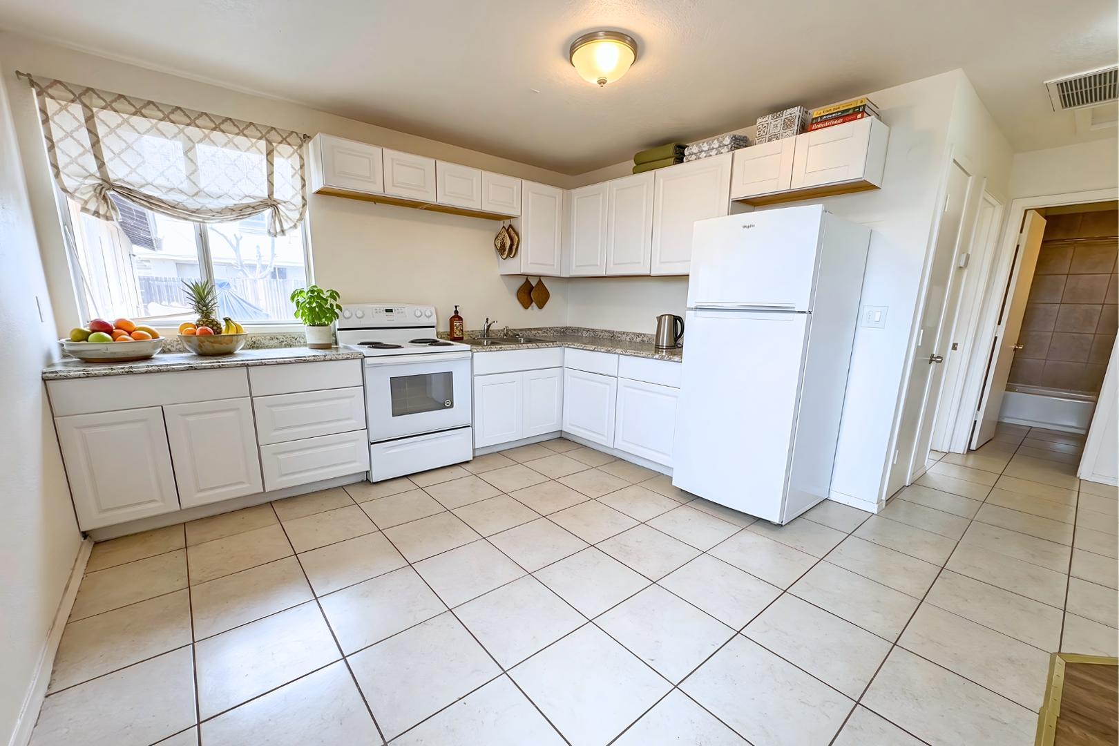1702 West Shangri-la Road, Unit 3 Phoenix, AZ 85029 - Photo 4 of 7 a kitchen with cabinets and white stainless steel appliances