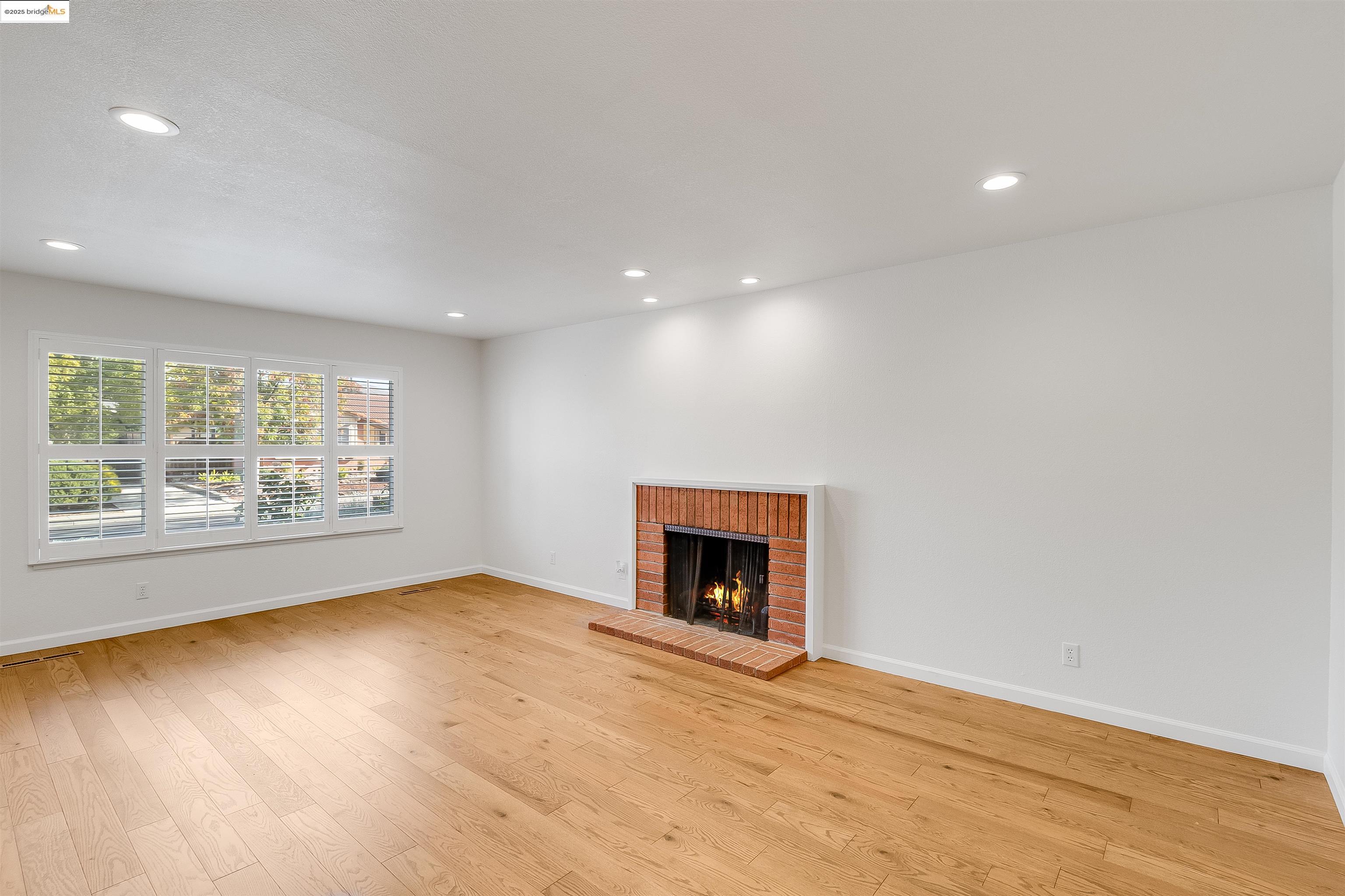 4656 Benbow Court Concord, CA 94521 - Photo 9 of 32 an empty room with a fireplace and wooden floor