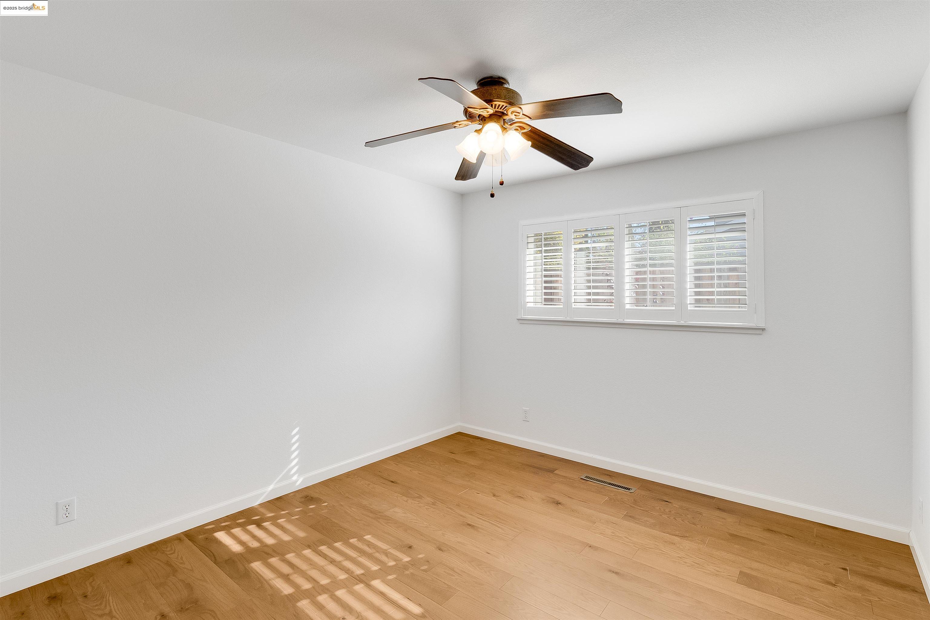 4656 Benbow Court Concord, CA 94521 - Photo 10 of 32 a view of an empty room with wooden floor and a window